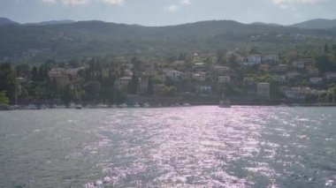 Güneşli dağları olan bir sahil kasabası, dinlenmek ve manzarayı izlemek için sakin ve çarpıcı bir ortam sağlıyor.