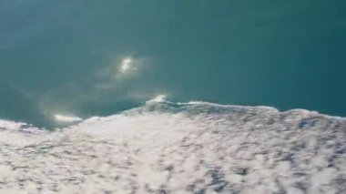 Güneşli su yüzeyinde hafif dalgalanmalar huzurlu ve sakin bir ortam yaratıyor. Huzurlu ve huzurlu bir manzara sunuyor.