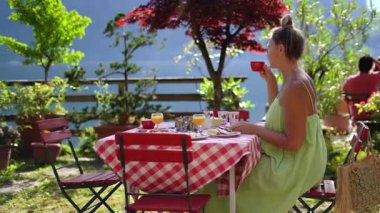 Kadınlar kafede oturur, kahve içer, dağlara bakar, yaz tatilinde dinlenir. Yüksek kalite 4k görüntü