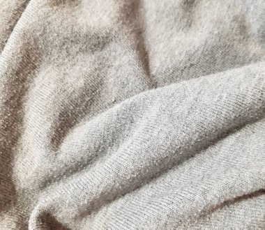 Gri ışıklı sıcak örülmüş kumaş. Arkaplan tasarımı, fotoğrafçılık. Tekstil, kumaş şablonu, modern yeni