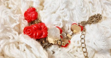 Hafif yün kumaşta kırmızı altın kolye. Moda tasarımı, fotoğrafçılık. Tekstil, kumaş şablonu, modern yeni