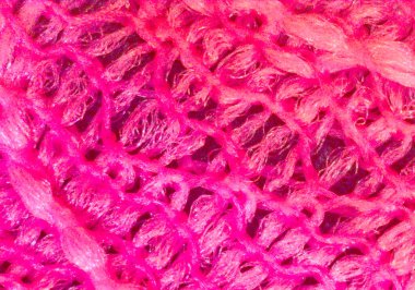 Parlak pembe desen, kumaş parçası, tekstil. Mikroskop altında görüntü, mikro fotoğrafçılık. Bilim, eğitim ve eğitim. Çoklu yakınlaştırma, yakın çekim. Yeni bilimsel fotoğrafçılık