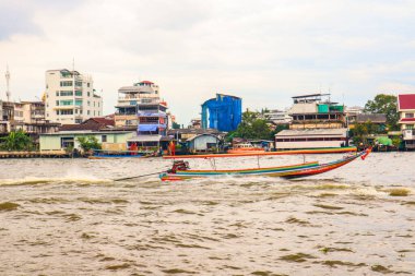 Turistler Chao Phraya nehri boyunca uzun bir gezi teknesine biniyorlar.