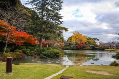 The garden in Umi Jigoku or sea hell featuring a pond with blue hot stream water. clipart