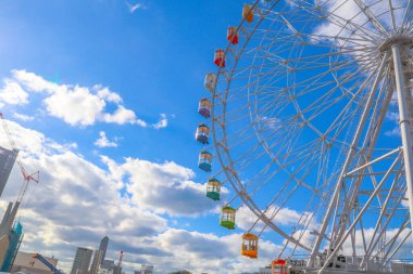 Mavi gökyüzüne karşı renkli dönme dolap, Japonya