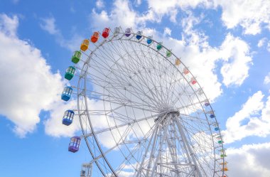 Mavi gökyüzüne karşı renkli dönme dolap, Japonya