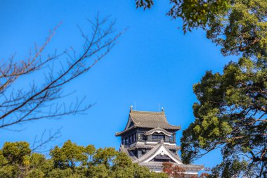 Güneşli mavi gökyüzünde teras ve balkondan Kumamoto Kalesi manzarası