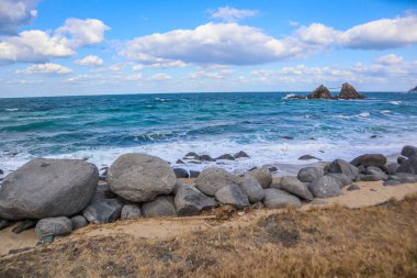 Mavi Gök ve Bulutlar Altında Huzurlu Rocky Shoreline