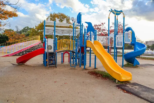 Bir sonbahar günü halk parkında slaytlarla ve tırmanma yapılarıyla renkli oyun alanı.