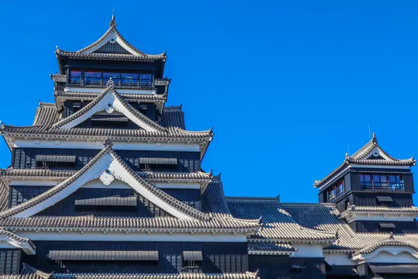 Açık mavi gökyüzüne karşı geleneksel mimarisi ile Japonya 'daki tarihi Kumamoto Kalesi.
