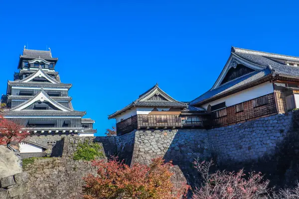 Açık mavi gökyüzüne karşı geleneksel mimarisi ile Japonya 'daki tarihi Kumamoto Kalesi.