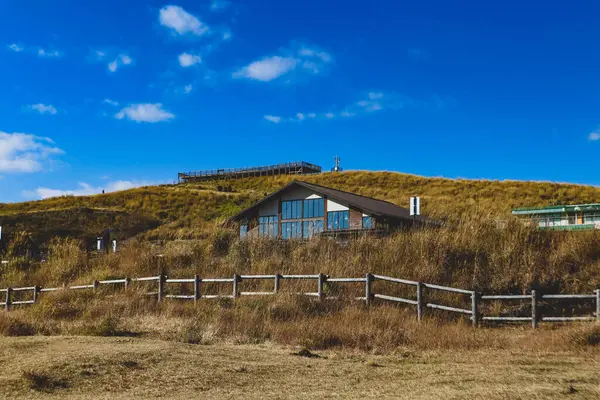 Çimenli bir tepede rahat, modern bir kulübe berrak mavi gökyüzü, huzurlu kır manzarası seyahat ve doğa kavramları için ideal..