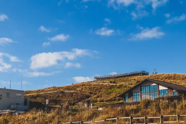 Çimenli bir tepede rahat, modern bir kulübe berrak mavi gökyüzü, huzurlu kır manzarası seyahat ve doğa kavramları için ideal..