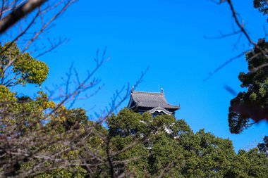 Açık mavi gökyüzüne karşı geleneksel mimarisi ile Japonya 'daki tarihi Kumamoto Kalesi.