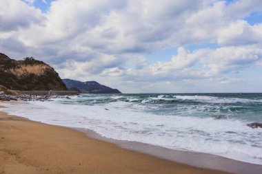 Sert Dalgalar ve Japon kıyı şeridi boyunca bulutlu gökyüzü ile Fırtınalı Okyanus Manzarası