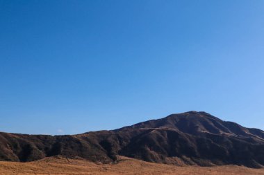 Japonya 'nın Kumamoto şehrinde Uçsuz bucaksız otlakların altında Aso Dağı manzarası