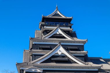 Açık mavi gökyüzüne karşı geleneksel mimarisi ile Japonya 'daki tarihi Kumamoto Kalesi.