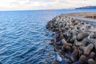 Günbatımında veya Gündoğumunda Tetrapod ve İskelenin Somut Sahil Savunma Yapısı