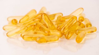 Beyaz arka planda yansımalı yağ kapsüllerini kapatın. Besin takviyesi balık yağı, omega 3, omega 6, omega 9, e vitamini, d vitamini ve a vitamini içerir. Seçici odak.