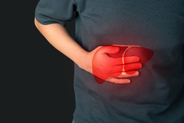 Dünya Hepatit Günü konsepti. Siyah arka planda karaciğer iltihabı olan karın ağrısı çeken bir erkek. Hepatitin sebepleri arasında viral enfeksiyon, alkol, uyuşturucu veya otoimmün.