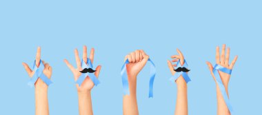 Men's health and Prostate cancer awareness campaign in November. Group of men hands holding blue ribbon awareness  with mustache to support and fight for health.  Movember campaign banner. clipart