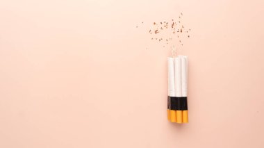 Kahverengi arka planda saatli bomba gibi bir sigara. Sigara içmek önlenebilir hastalık ve ölüm sebebidir. Dünya tütün günü konsept şablonu yok.