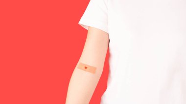 Kan bağışı. Kırmızı arka planda alçıdan kalbi olan insan elleri. Anemi, orak hücre hastalığı, hemofili, lösemi ve ITP gibi hematolojik bozukluklar..