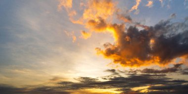 Güneşin doğuşuyla gökyüzünün resmi. Güneş ışınlı altın bulutlar. Doğal manzara gösterimi