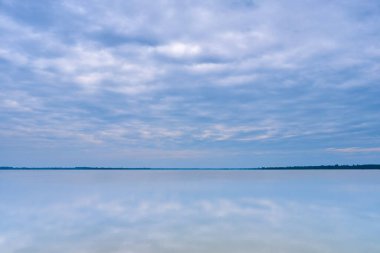 Suyu yansıtan bulutlarla sakin göl