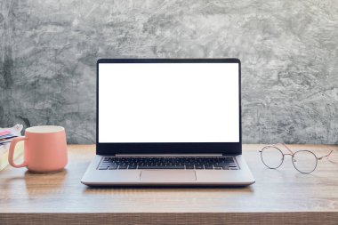 Computer laptop on the table in the room, concrete wall background.