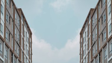 Gökyüzü arkaplanı olan apartman binası.
