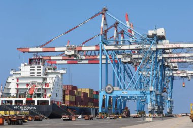 Crane and vehicle activity at the ship port.