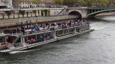 Turistler Paris 'teki Seine Nehri' nde bir tur teknesinde geziyorlar..