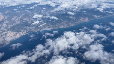 Bulutların üstünde mavi gökyüzü olan uçak penceresinden hava manzarası. 
