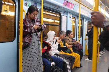 Tanımlanamayan yolcular metroda cep telefonu kullanıyor.
