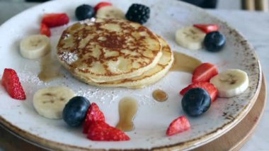 Akçaağaç pekmezi, muz ve çilekli bir tabağın üzerine dökülür..