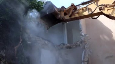 Bir buldozer bir evi yıkıyor, duman çıkıyor.. 