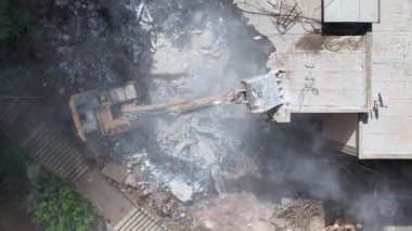 Bir evin sökülmesi. Kazıcı yeni bir inşaat projesi için barakaları yıkıyor. 