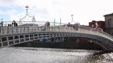 DUBLIN, IRELAND - 25 Mart 2023 Dublin şehir merkezindeki Liffey Nehri üzerindeki meşhur yaya köprüsünün gündüz görüntüsü.