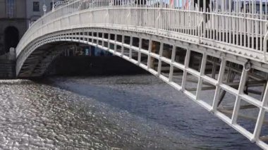 Dublin şehir merkezindeki Liffey Nehri üzerindeki ünlü yaya Penny Hapenny Köprüsü 'nün gündüz görüntüsü.