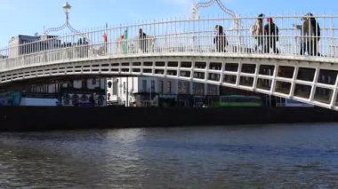 DUBLIN, IRELAND - 25 Mart 2023 Dublin şehir merkezindeki Liffey Nehri üzerindeki meşhur yaya köprüsünün gündüz görüntüsü.