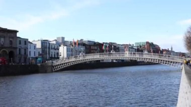 DUBLIN, IRELAND - 25 Mart 2023 Dublin şehir merkezindeki Liffey Nehri üzerindeki meşhur yaya köprüsünün gündüz görüntüsü.