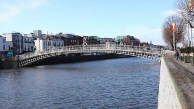DUBLIN, IRELAND - 25 Mart 2023 Dublin şehir merkezindeki Liffey Nehri üzerindeki meşhur yaya köprüsünün gündüz görüntüsü.