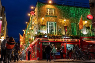 Dublin şehir merkezindeki Liffey Nehri üzerindeki ünlü yaya Penny Hapenny Köprüsü gece görüşü.