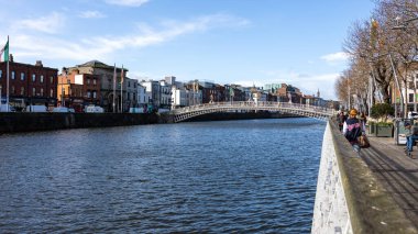 DUBLIN, IRELAND - 25 Mart 2023 Dublin şehir merkezindeki Liffey Nehri üzerindeki meşhur yaya köprüsünün gündüz görüntüsü.