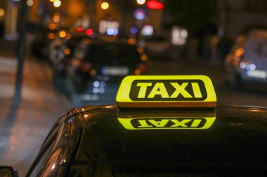 Parlak sarı bir taksi işaretinin yakın çekim görüntüsü..