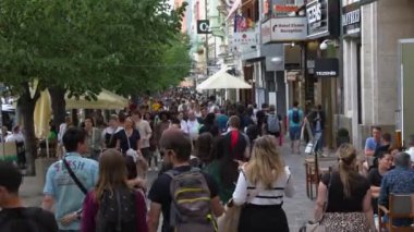 Alışveriş ve turizm alanlarında yürüyen isimsiz bir kalabalık. 