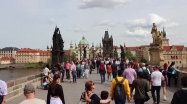 Prag'daki Charles Köprüsü üzerinde yürüyen insanlar.