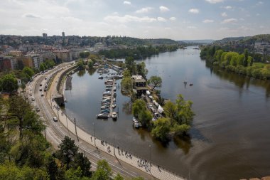 Prag 'daki Vltava Nehri manzarası, küçük tekne ve yol trafiği.