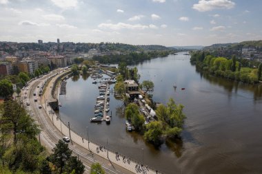 Prag 'daki Vltava Nehri manzarası, küçük tekne ve yol trafiği.